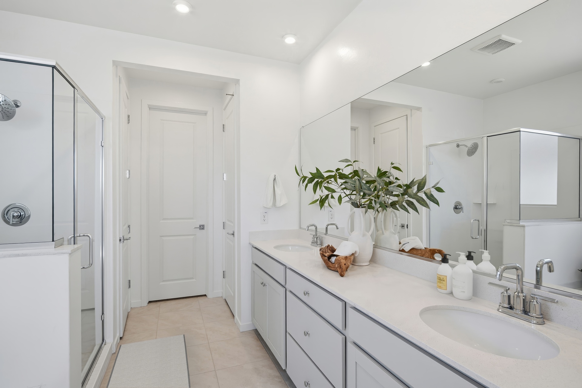 spacious bathroom with white countertops, chrome faucets, and white cabinets