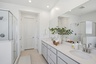 spacious bathroom with white countertops, chrome faucets, and white cabinets