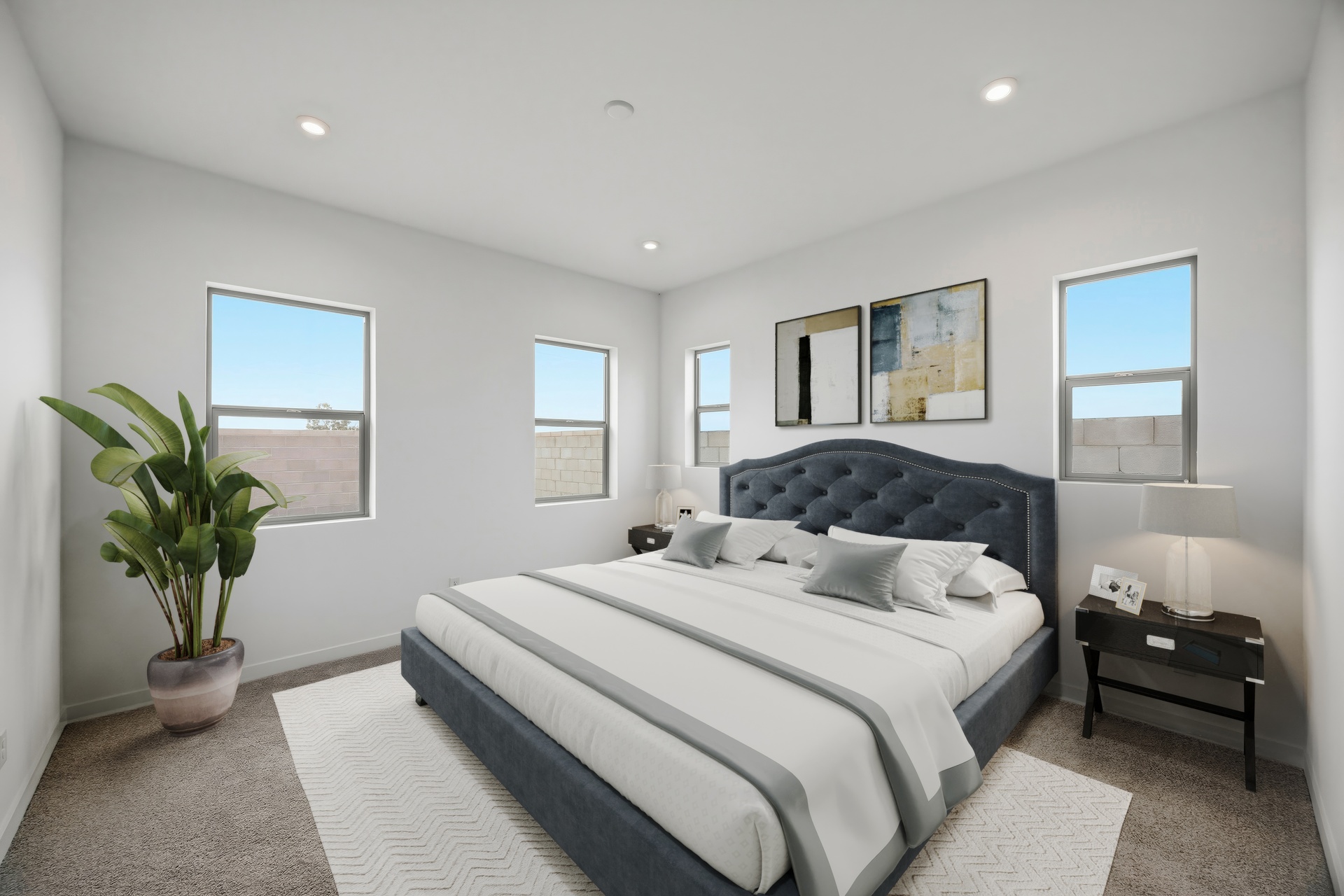 spacious bedroom with a large grey bed, wooden nightstands, and an indoor plant
