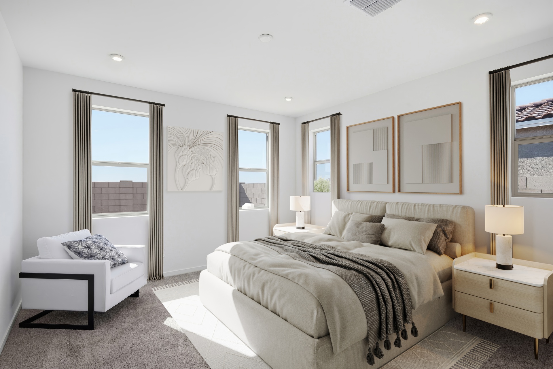 spacious bedroom with a light beige bed, a white rug, and a white accent chair 