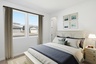 bedroom with a large bed with navy blue accent colors and a white nightstand