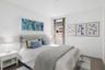 bedroom with a large bed, blue accent colors, and white nightstands