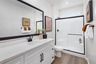bathroom with neutral floors and white cabinets