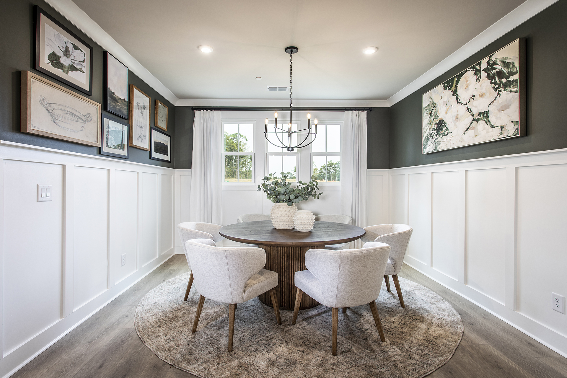 formal dining room with round table and wainscoting on the walls