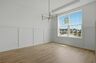 dining room with large windows, light wood floors and an accent chandelier