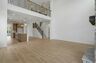 great room with two-story stone fireplace, wood floors, and large windows