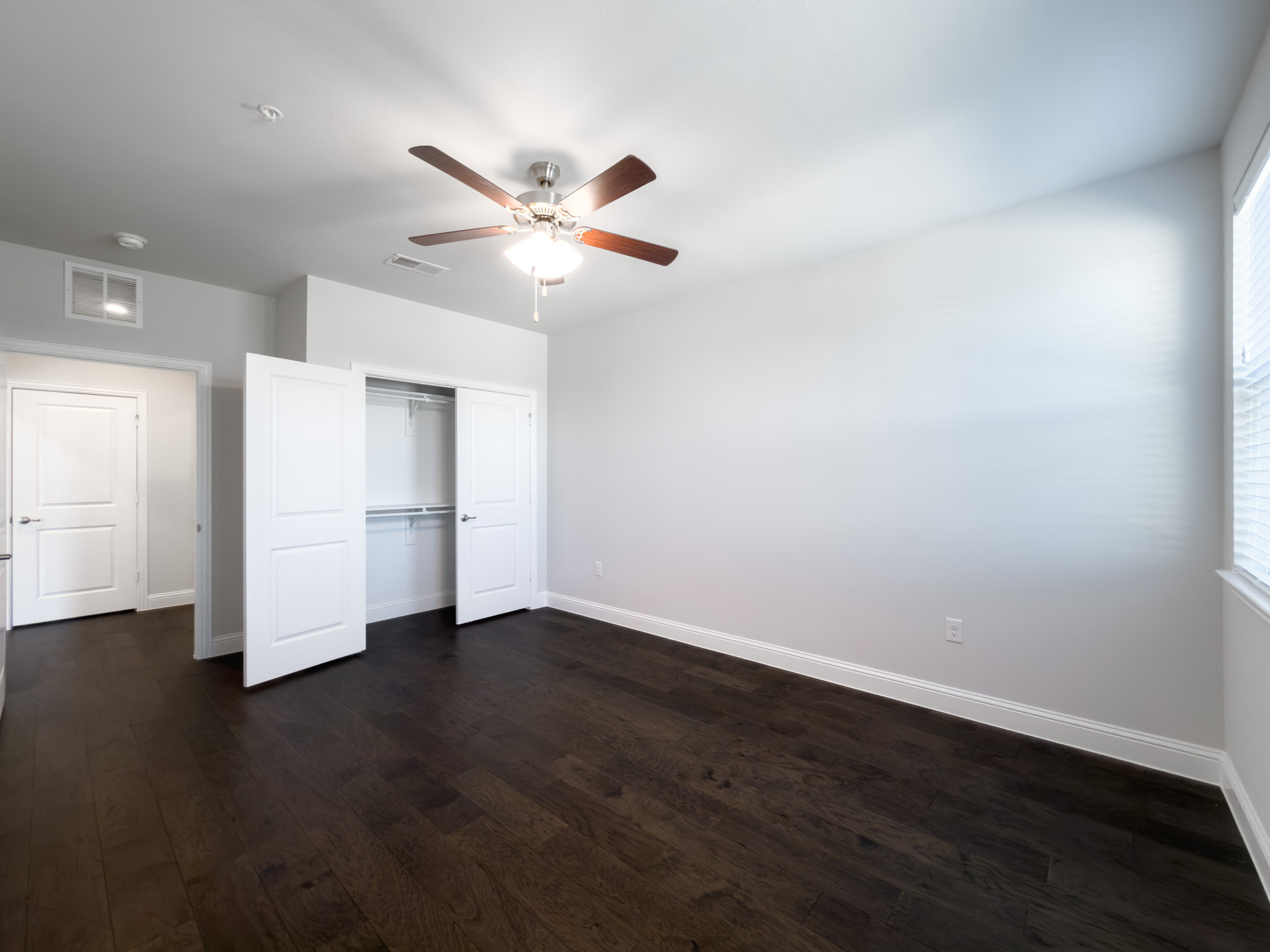 guest bedroom with hardwood flooring and closet