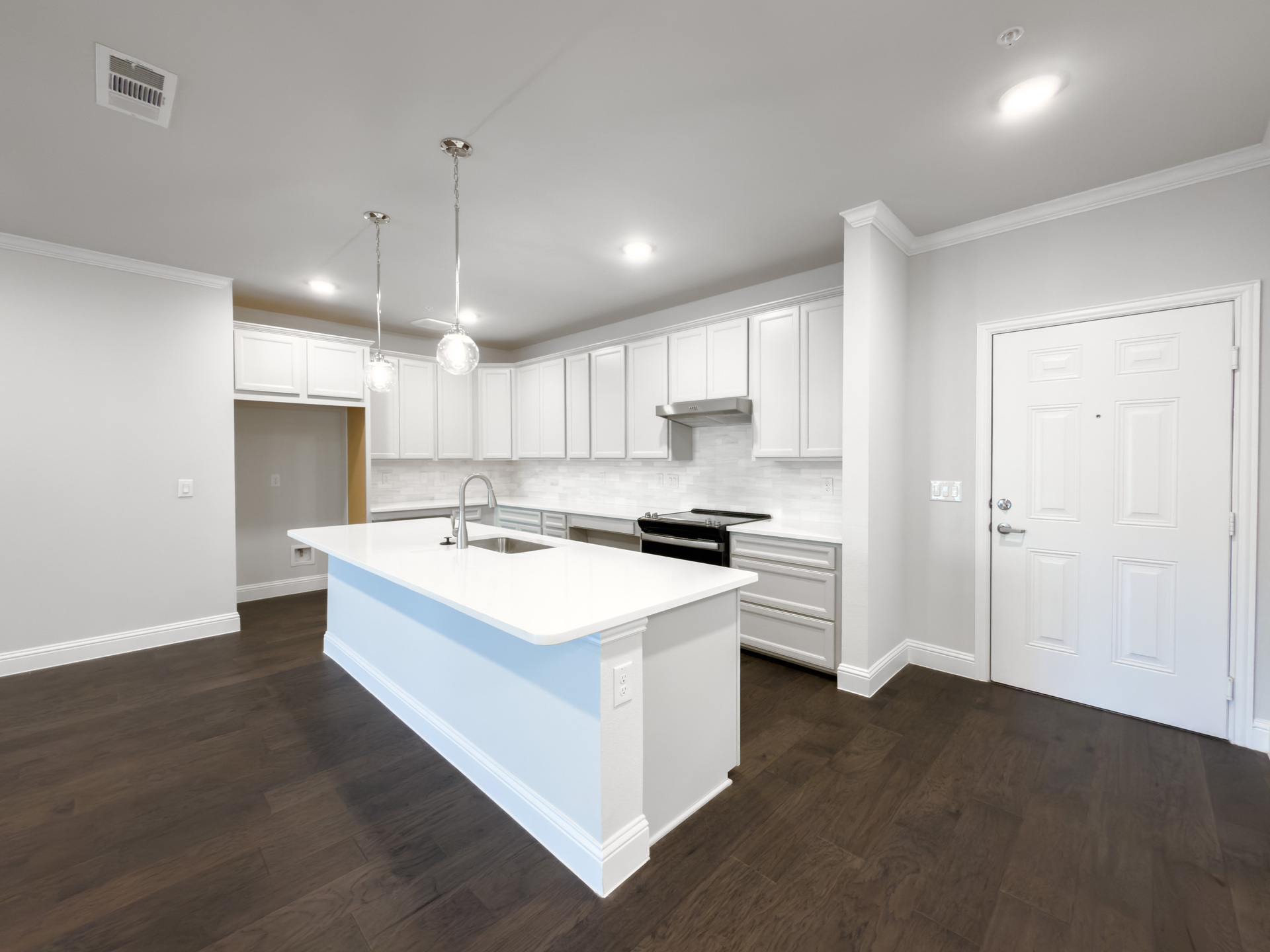 open kitchen with light tan cabinets and hardwood flooring