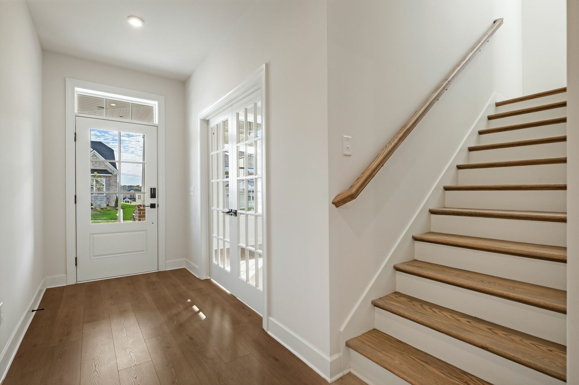 entry way with wood floors a view of the staircase and study