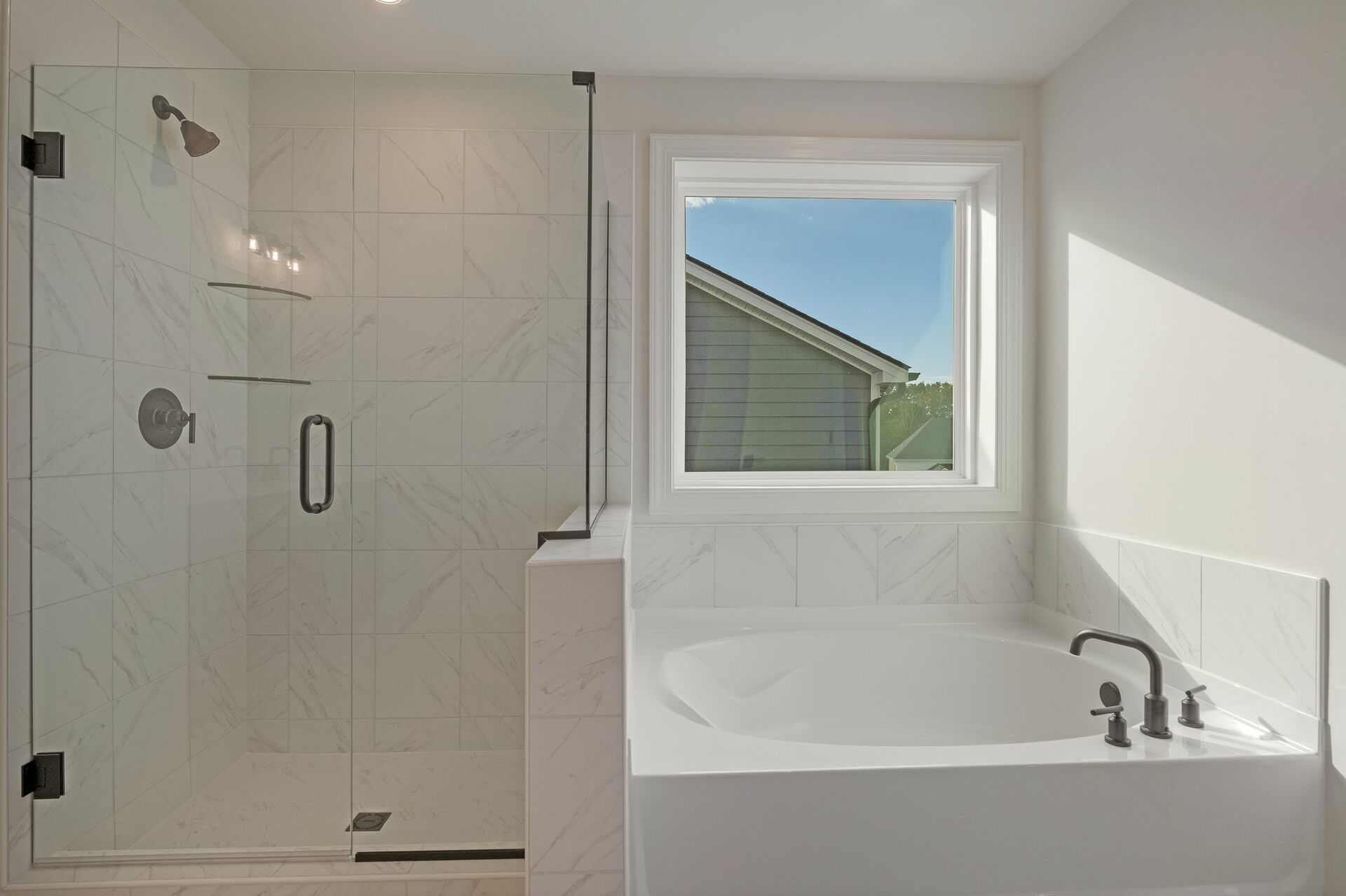 primary bathroom with glass shower and large soaking tub