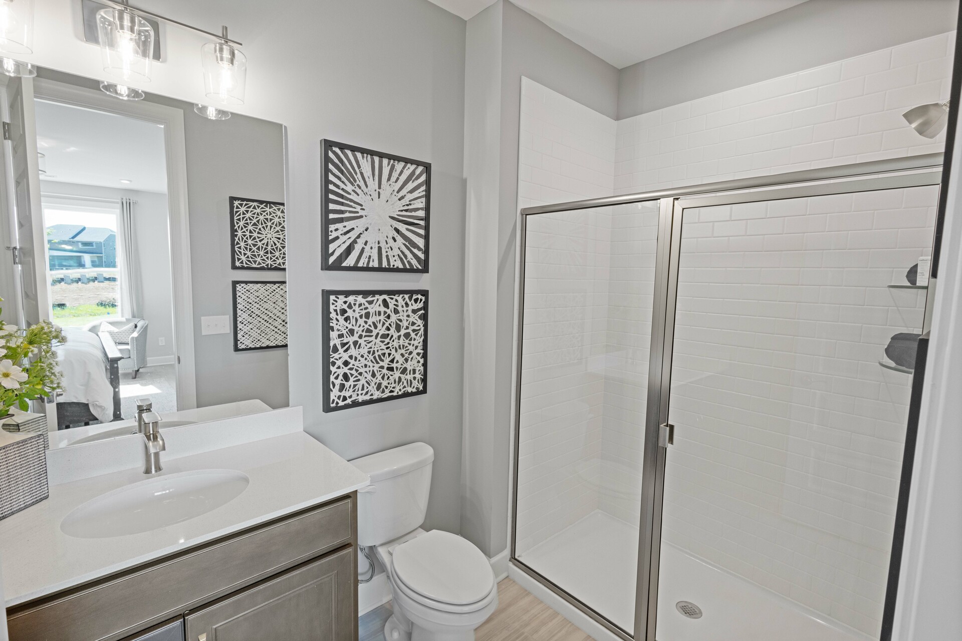 secondary bathroom with gray cabinet, white countertops, and a glass walk-in shower