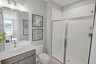 secondary bathroom with gray cabinet, white countertops, and a glass walk-in shower