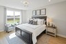 secondary bedroom with carpet flooring, bed, nightstands, and large windows