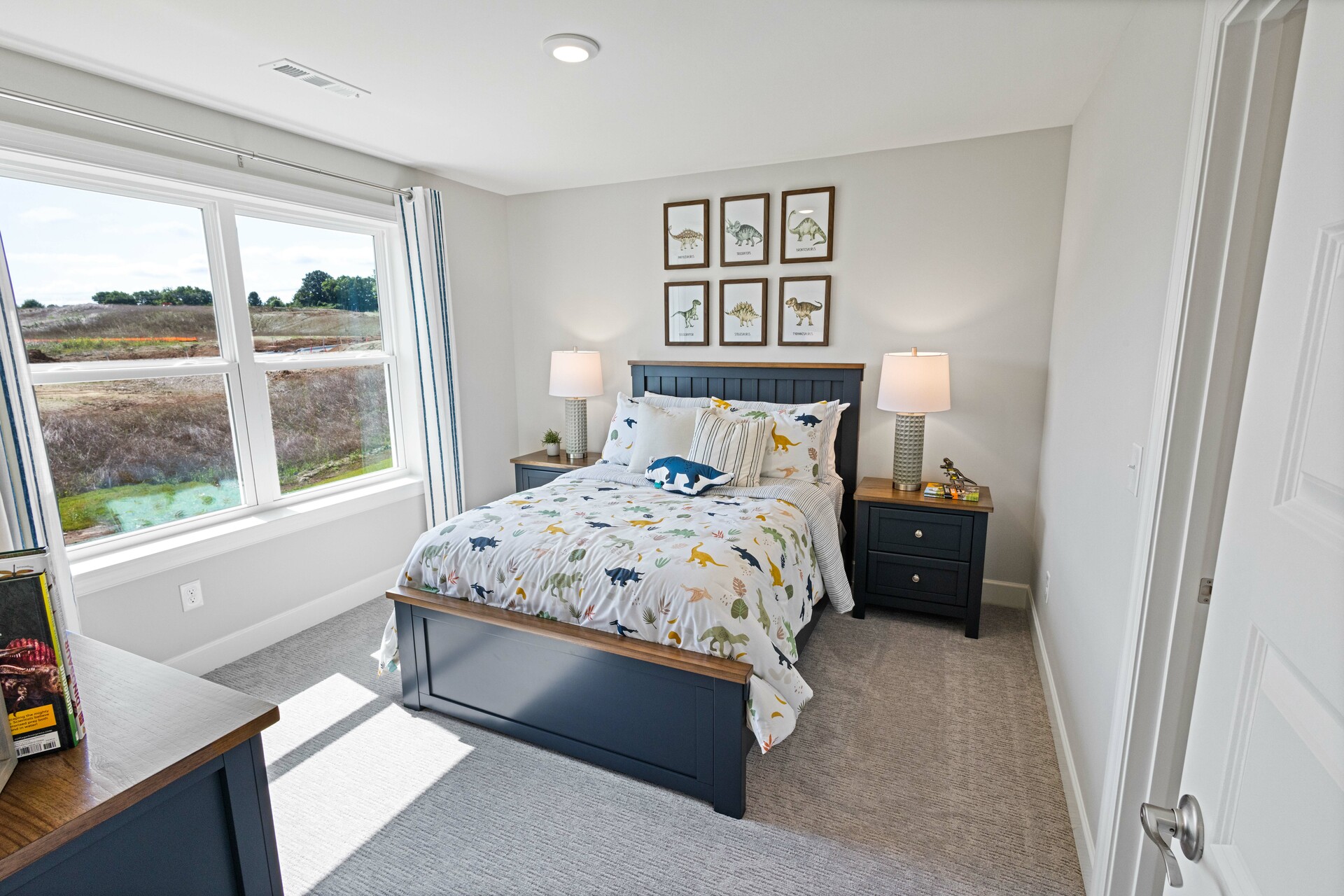 secondary bedroom with carpet flooring, bed, nightstands, and large windows