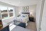 secondary bedroom with carpet flooring, bed, nightstands, and large windows