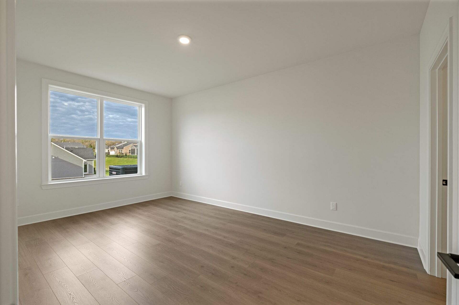 secondary bedroom with carpet flooring, white trip, and large windows