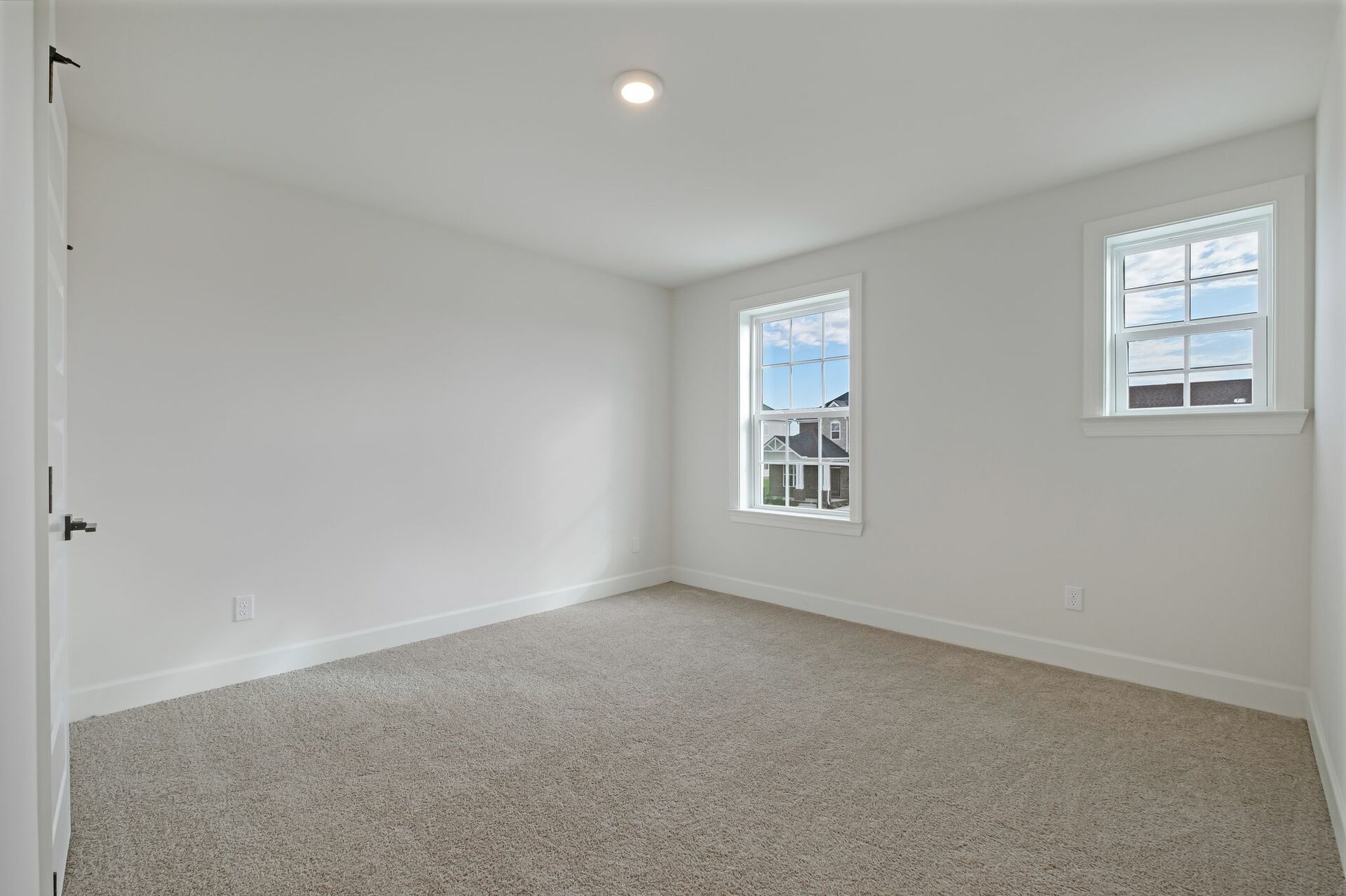 secondary bedroom with carpet flooring, white trip, and large windows