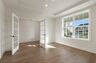 study with wood flooring, large windows, and french doors