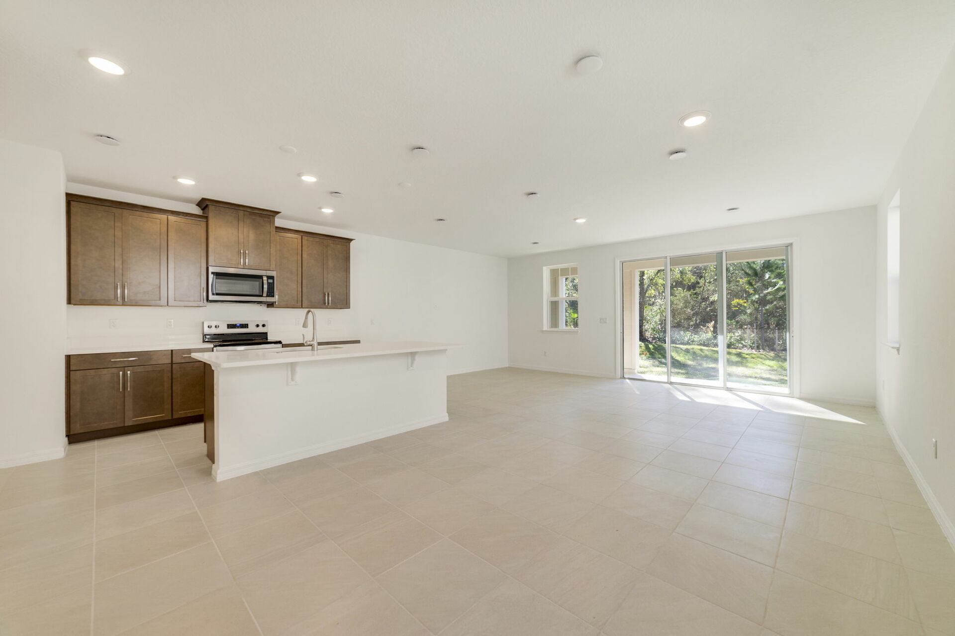 great room with view of kitchen and sliding glass door for patio