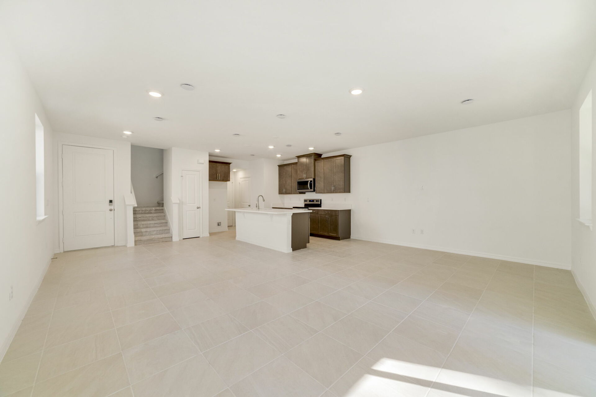 great room with view of kitchen and sliding glass door for patio