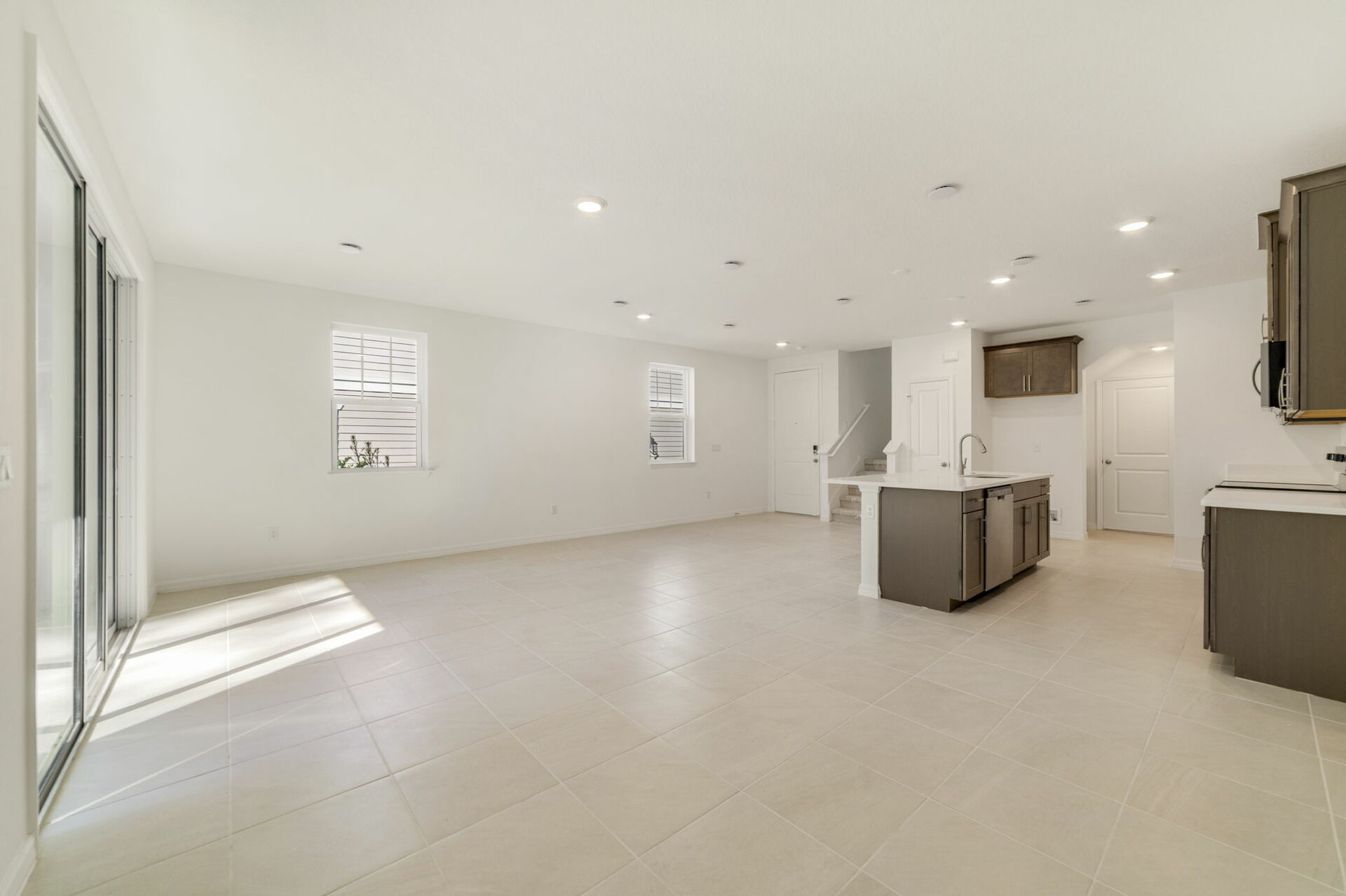 great room with view of kitchen and sliding glass door for patio