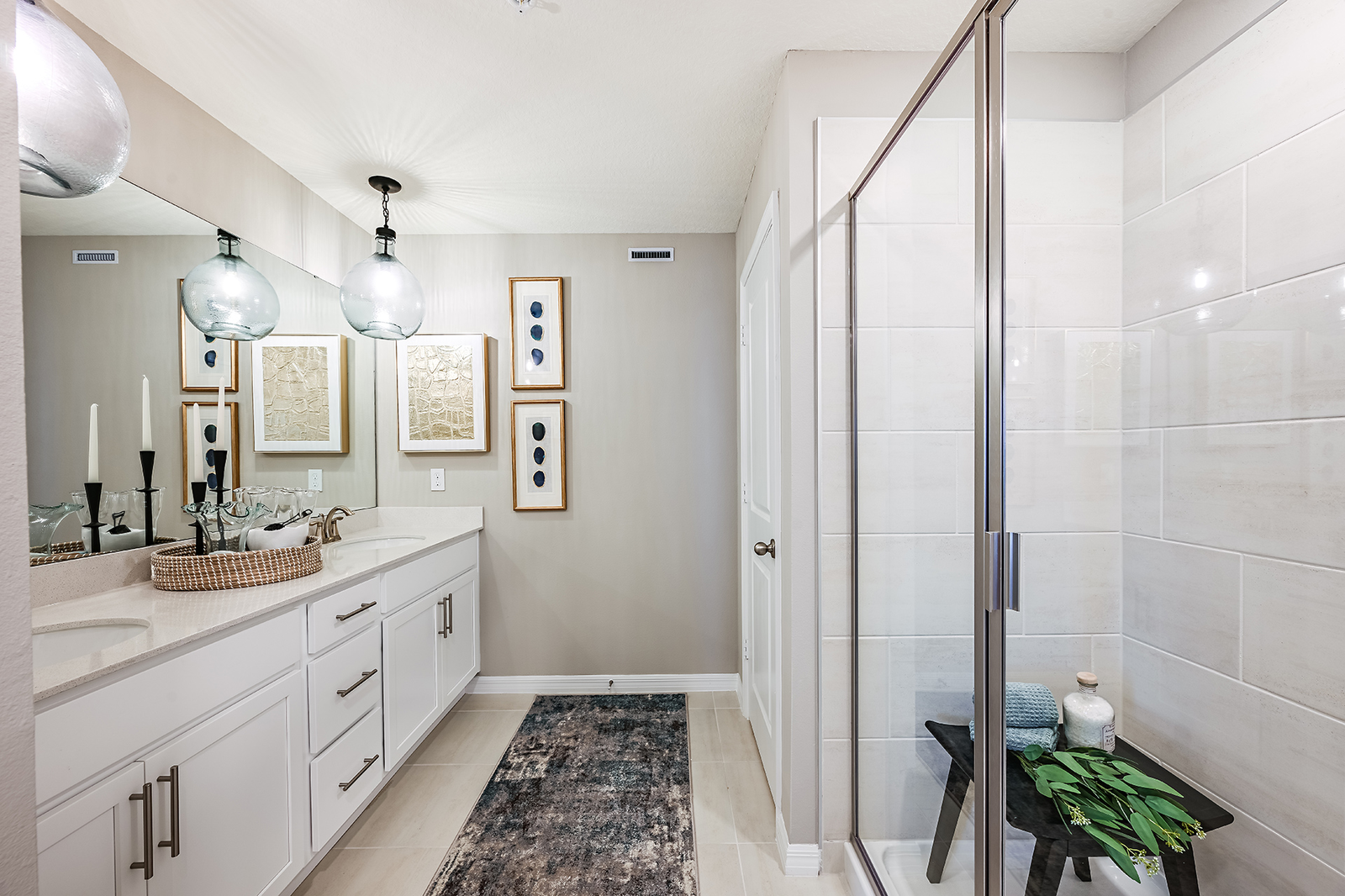 primary bathroom with tile shower and dual sinks