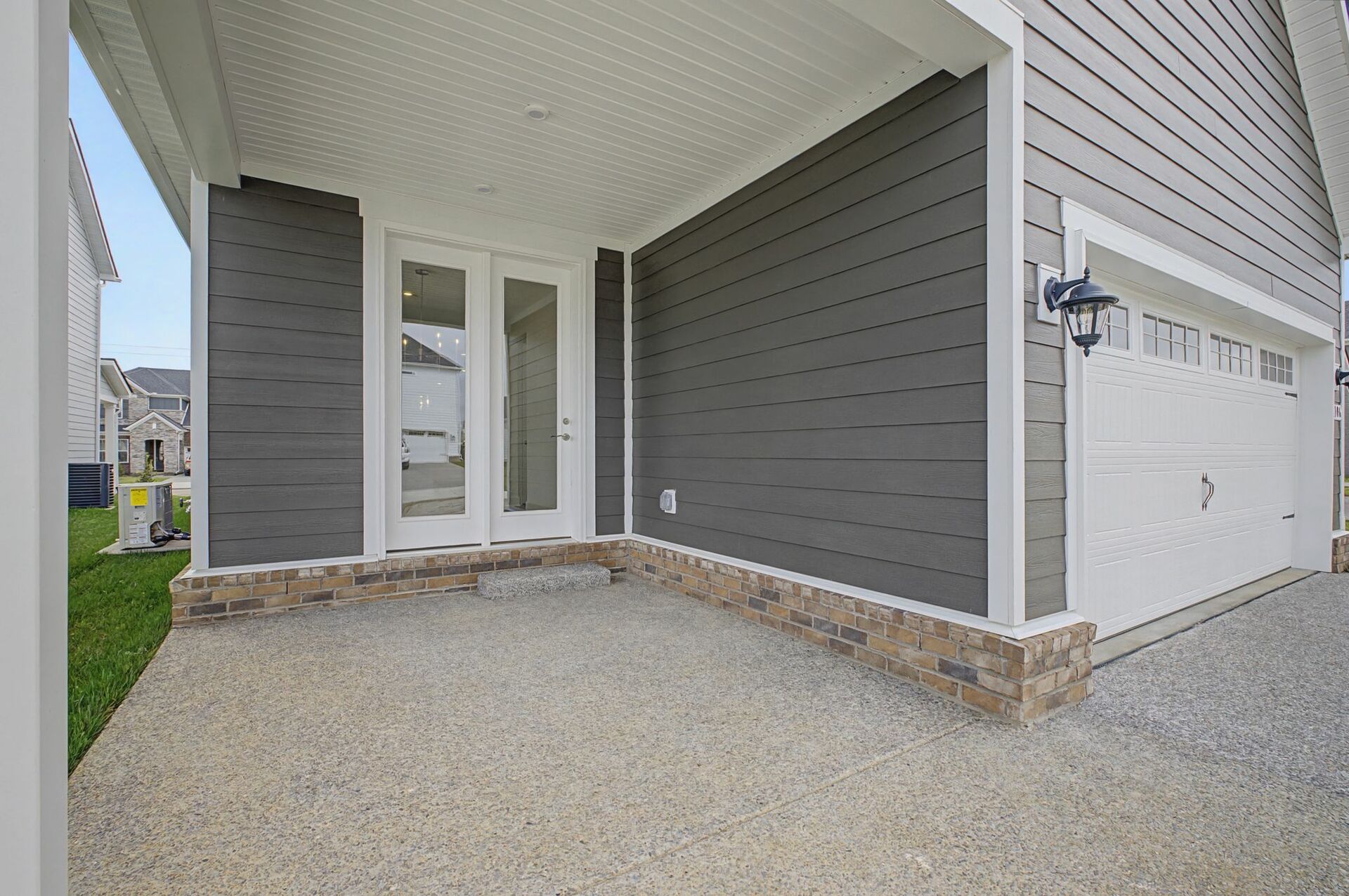 covered patio with cement flooring, white trim, and glass doors to the inside
