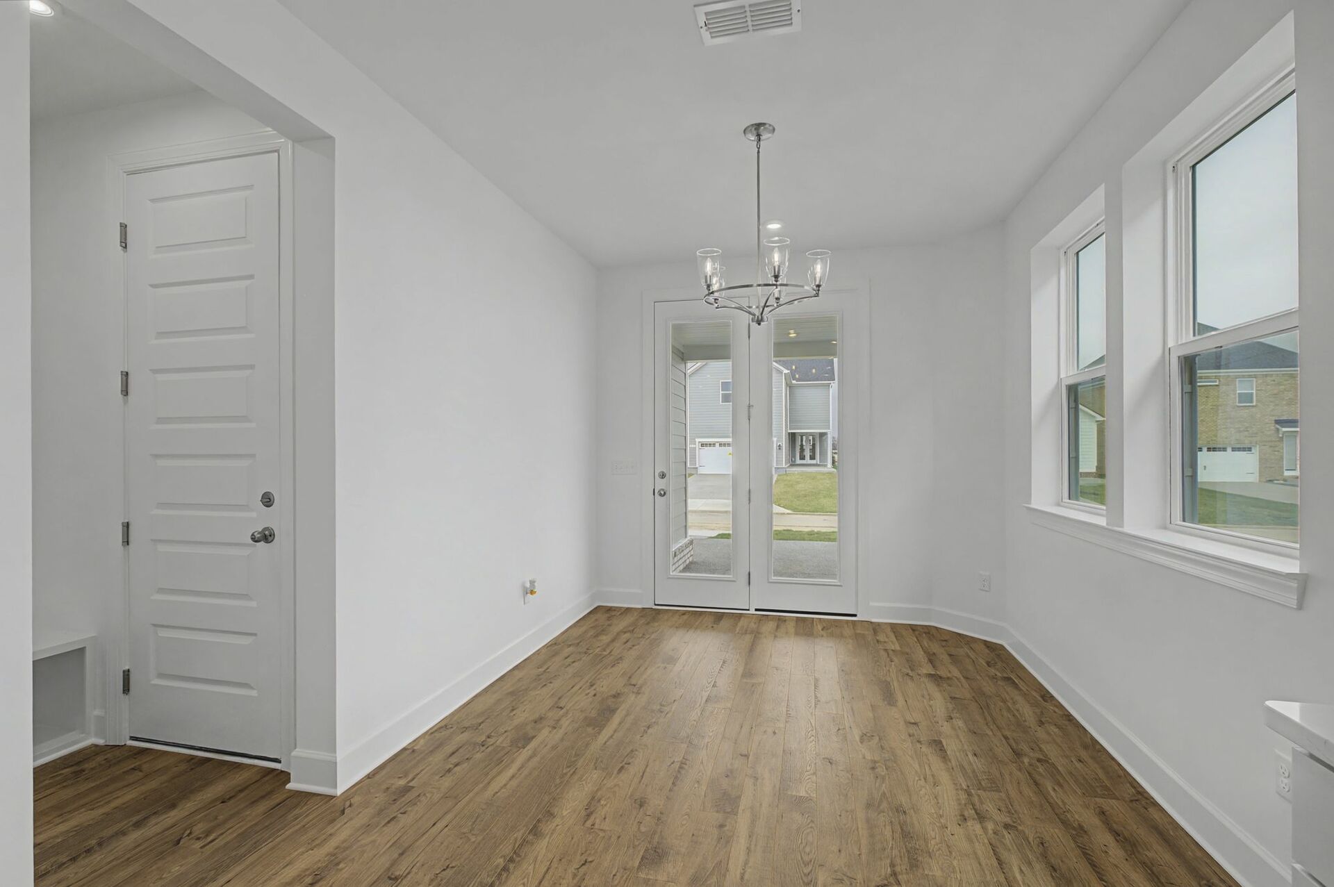 dining room with wood flooring, large windows, and glass doors to the outside