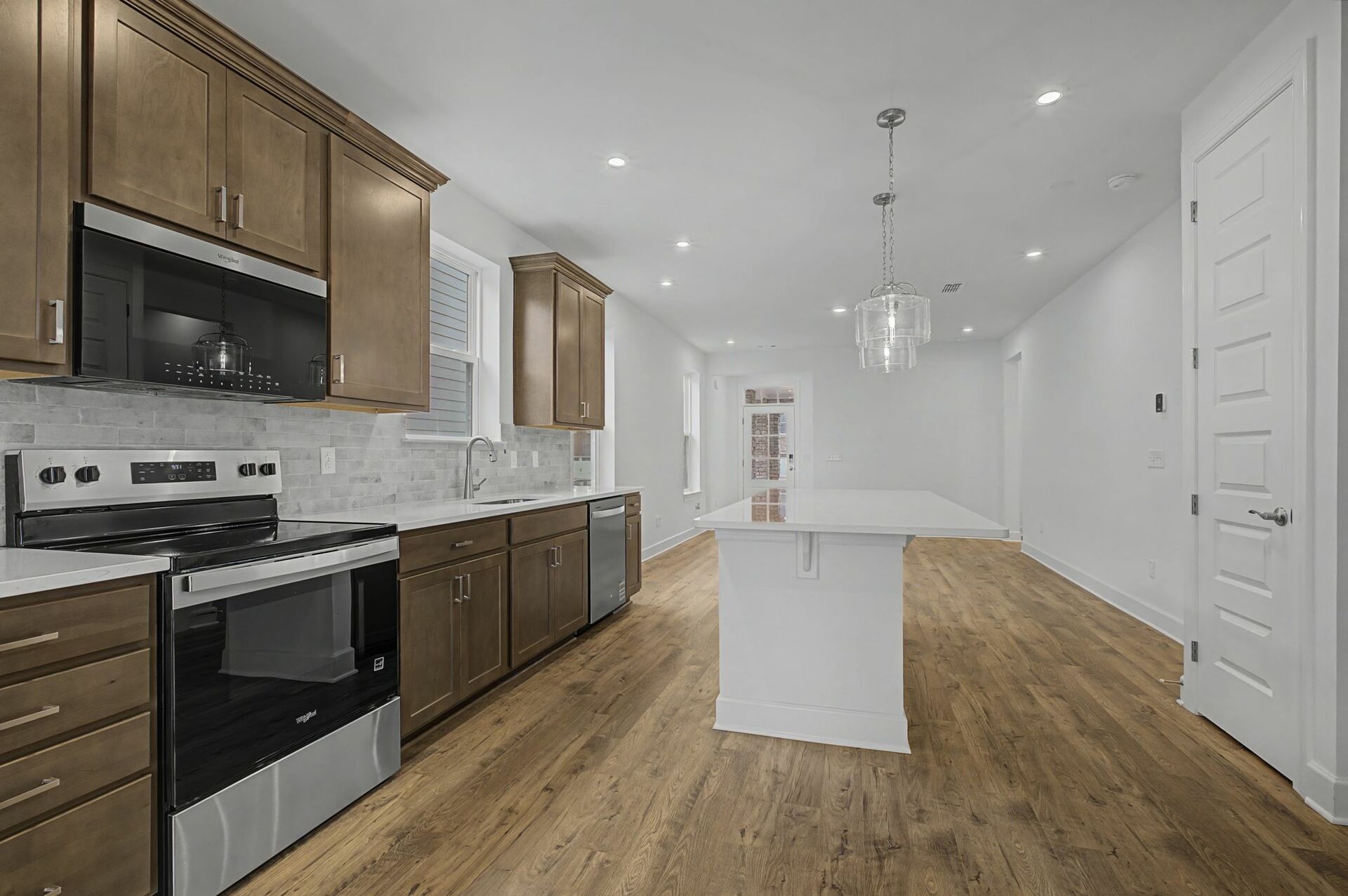 kitchen with wood flooring, wood cabinets, and white countertops