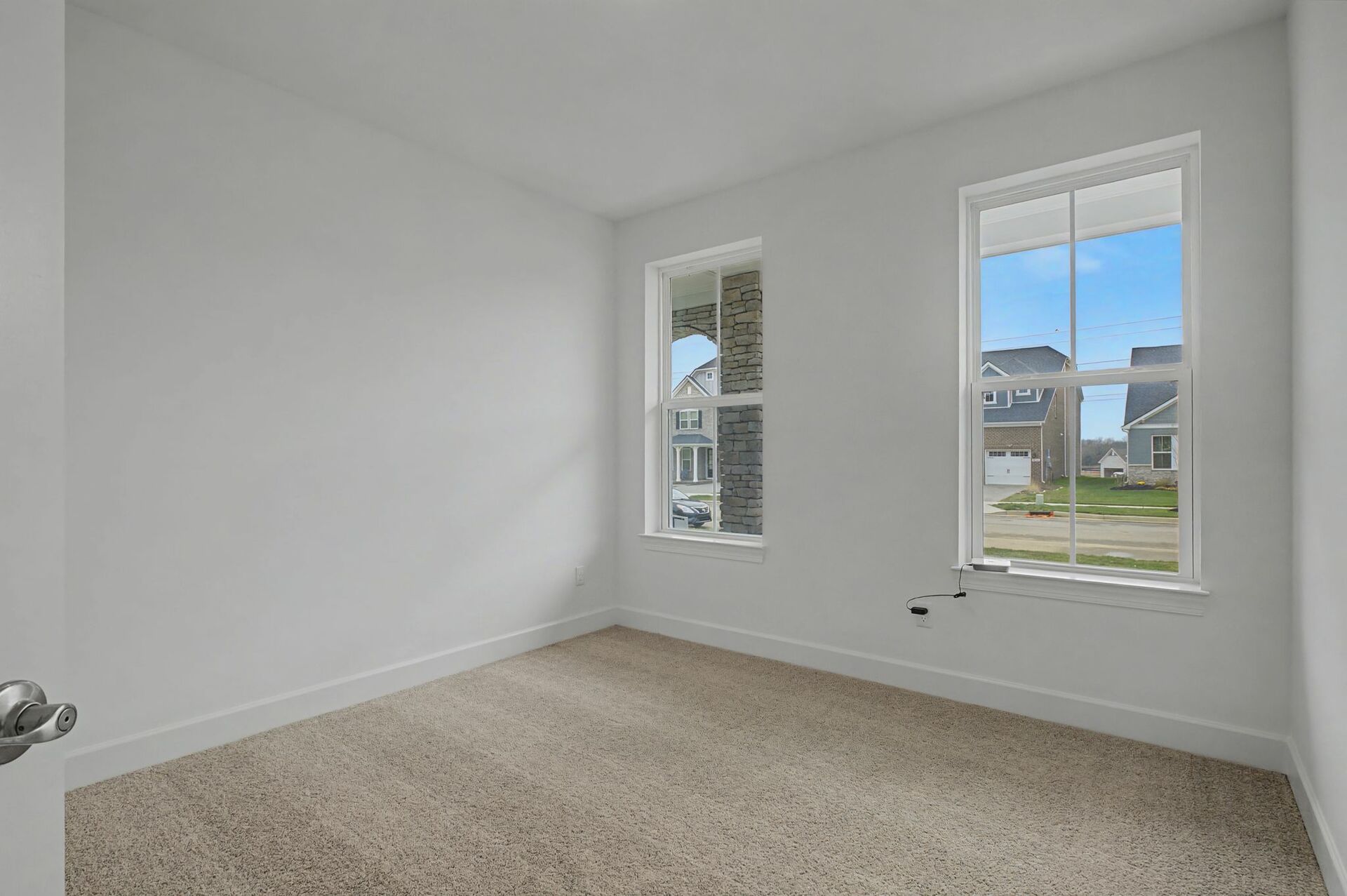 secondary bedroom with carpet flooring, white trim, and large windows