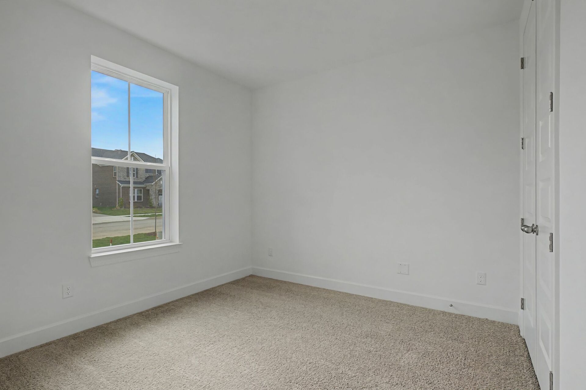 secondary bedroom with carpet flooring, white trim, and large windows