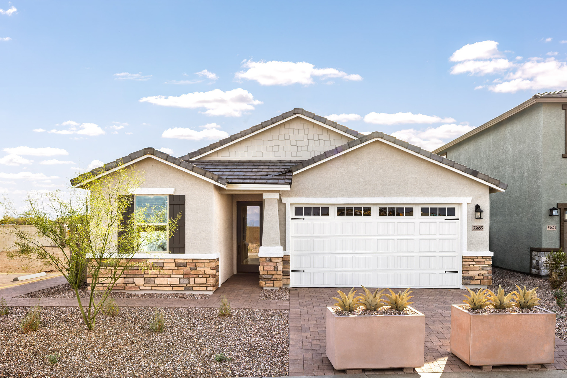 single-story home with desert landscaping and paver driveway