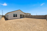 spacious dirt backyard with a concrete block wall and side gate