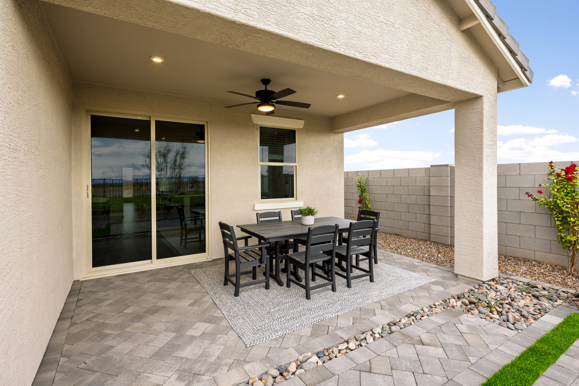 covered patio with pavers, outdoor ceiling fan, and grey outdoor furniture