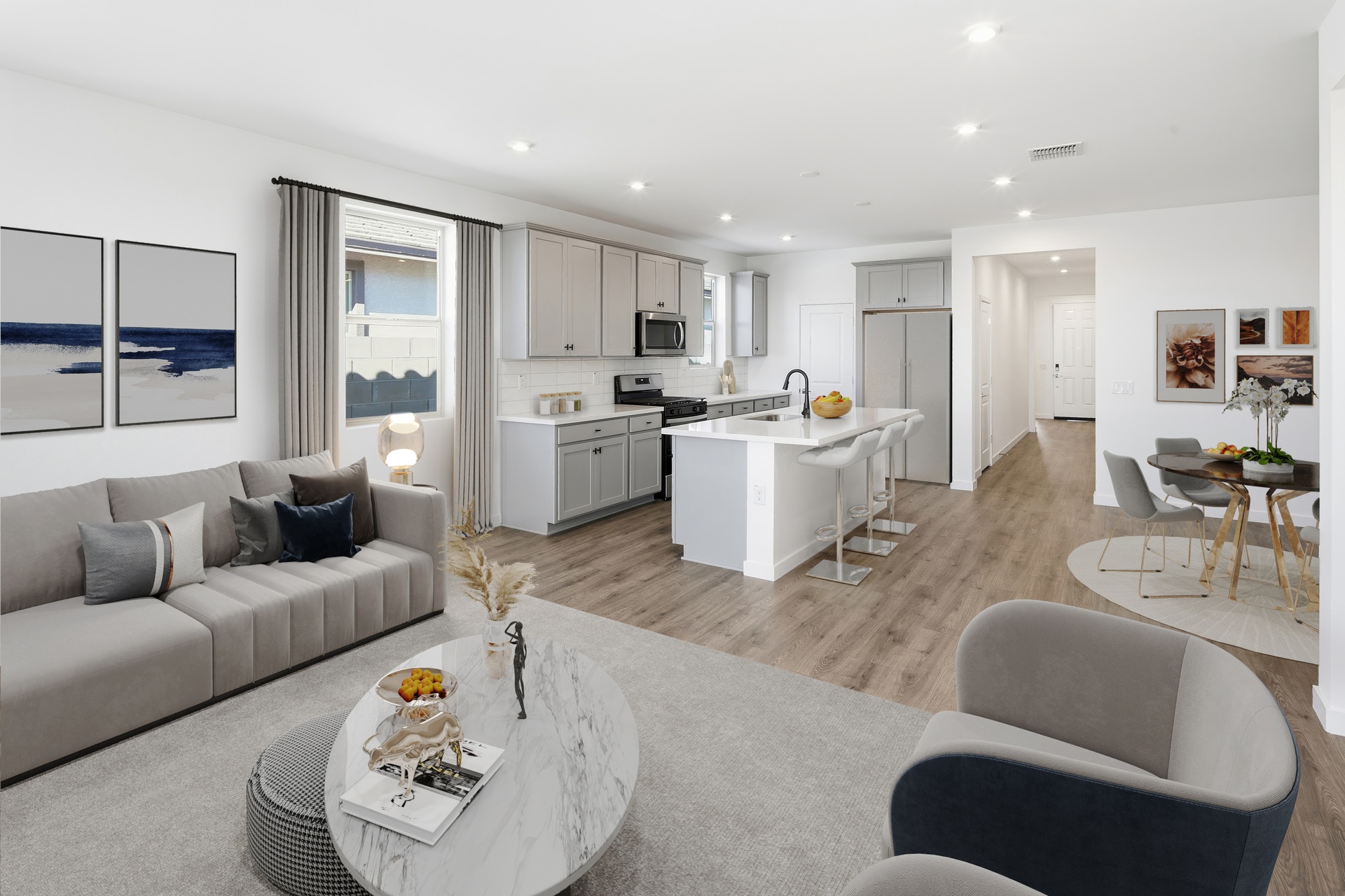 open concept space with large grey couch, grey rug, and marble coffee table 