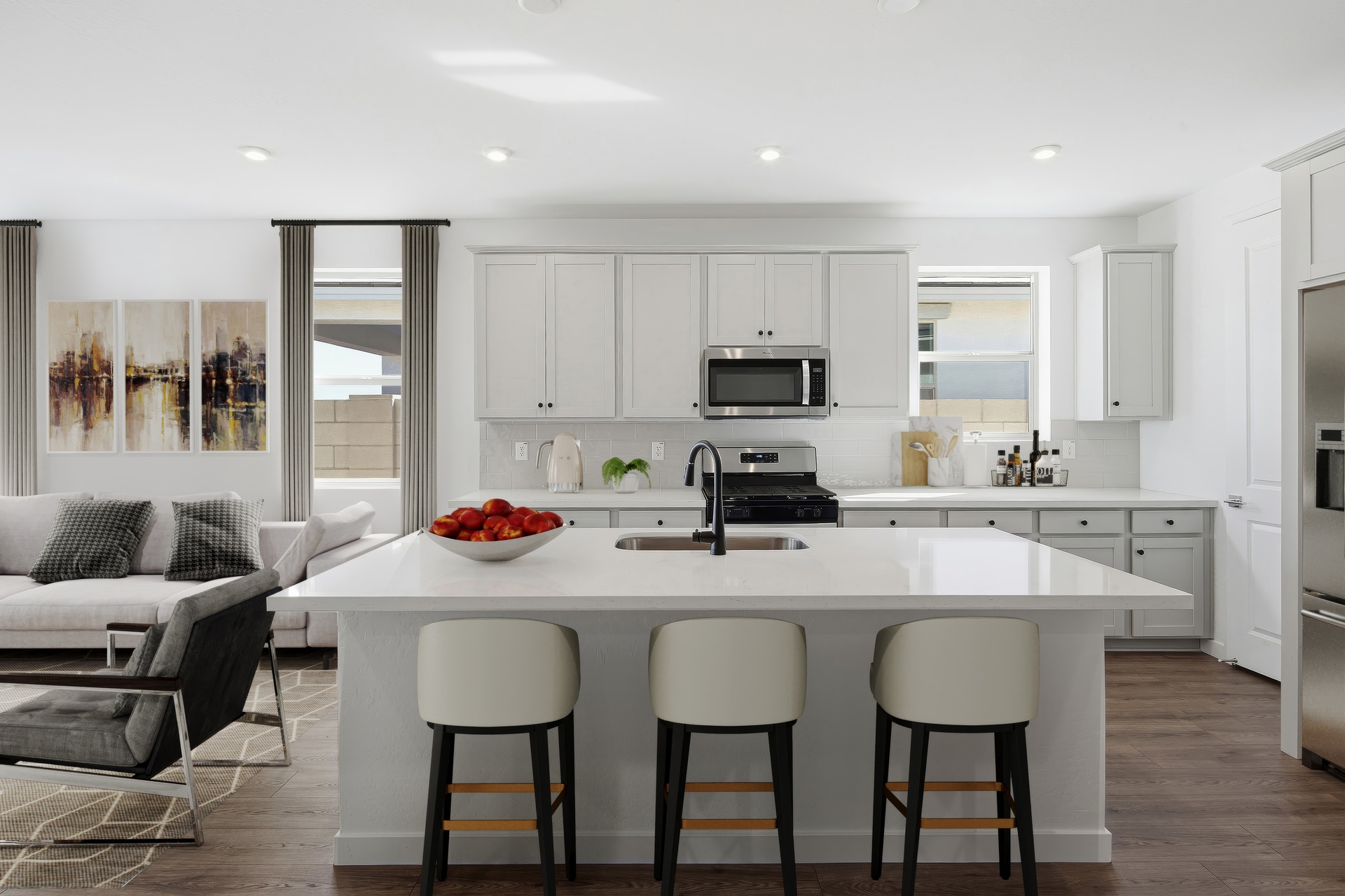 kitchen with quartz countertops. stainless-steel appliances, and white barstools