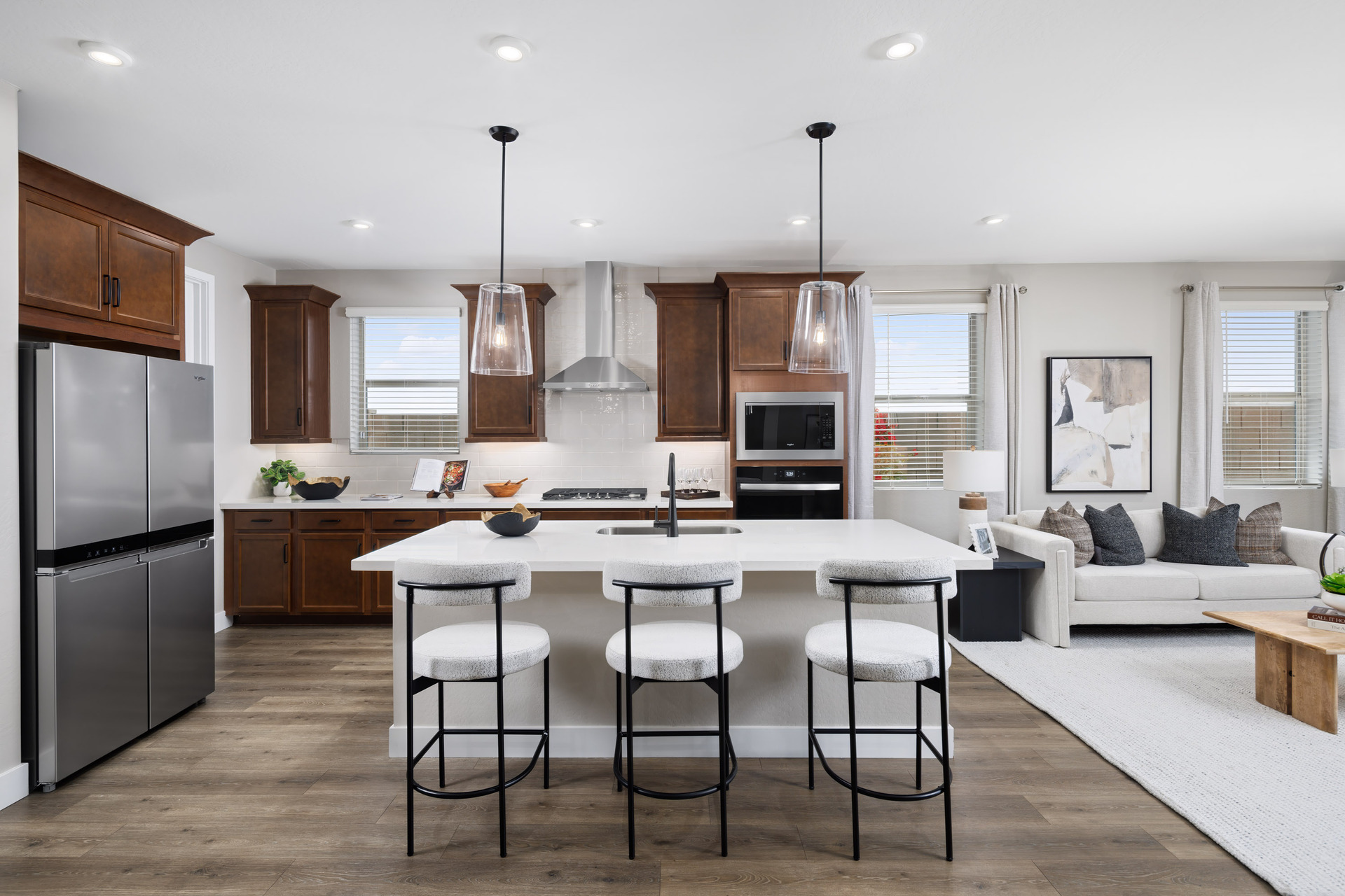kitchen with brown cabinets, quartz countertops, and white barstools
