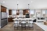 kitchen with brown cabinets, quartz countertops, and white barstools