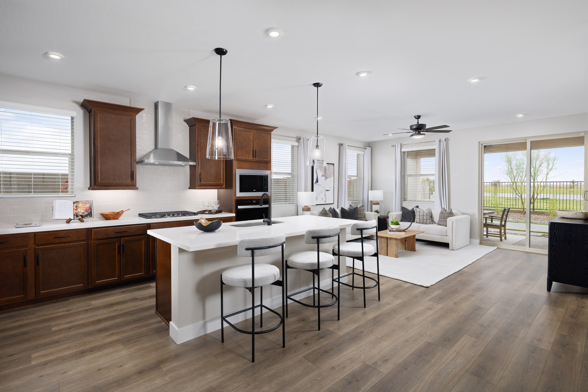 kitchen with brown cabinets, quartz countertops, and white barstools