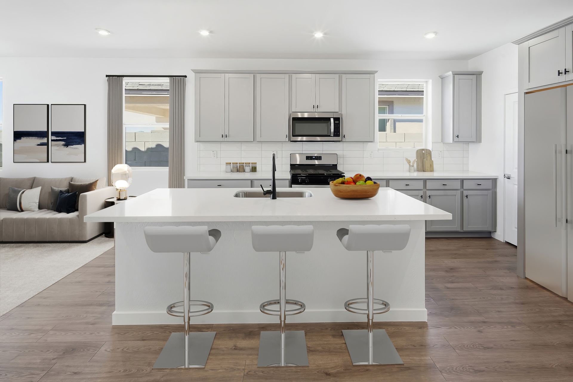 spacious kitchen with quartz countertops, stainless steel appliances, and grey cabinets