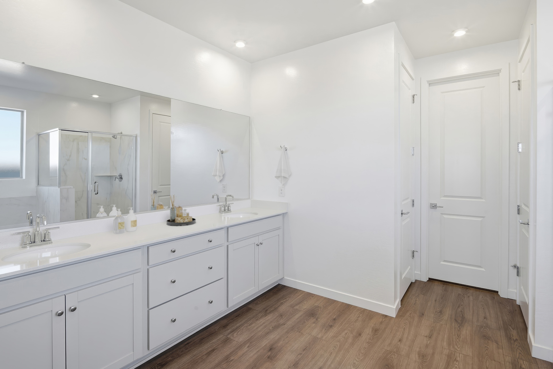 spacious bathroom with white countertops, double sink, and chrome faucets