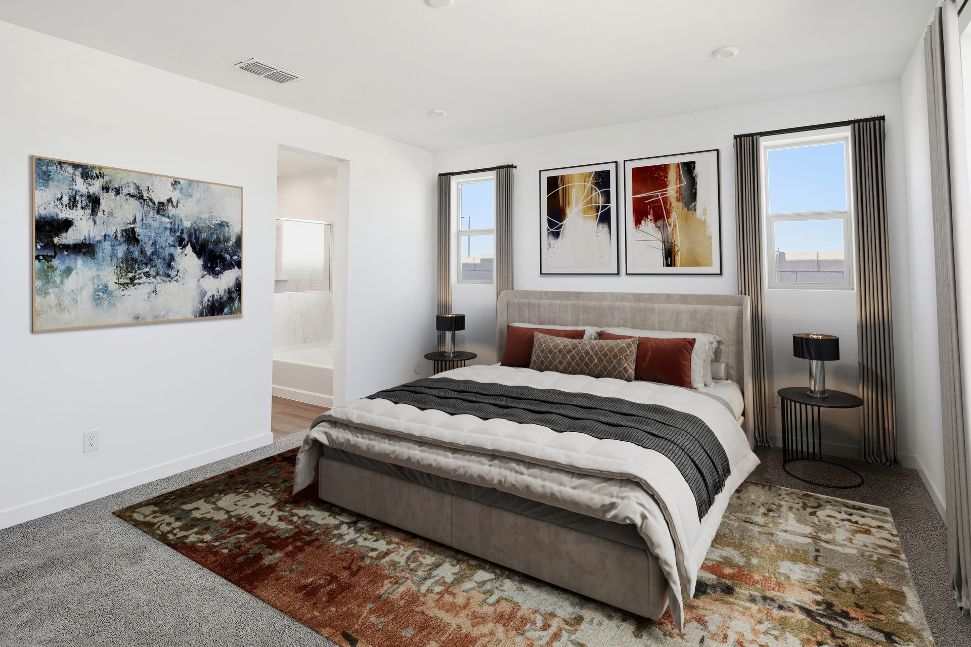 spacious room with a large bed, a large multi-colored rug, and sedona orange pillows