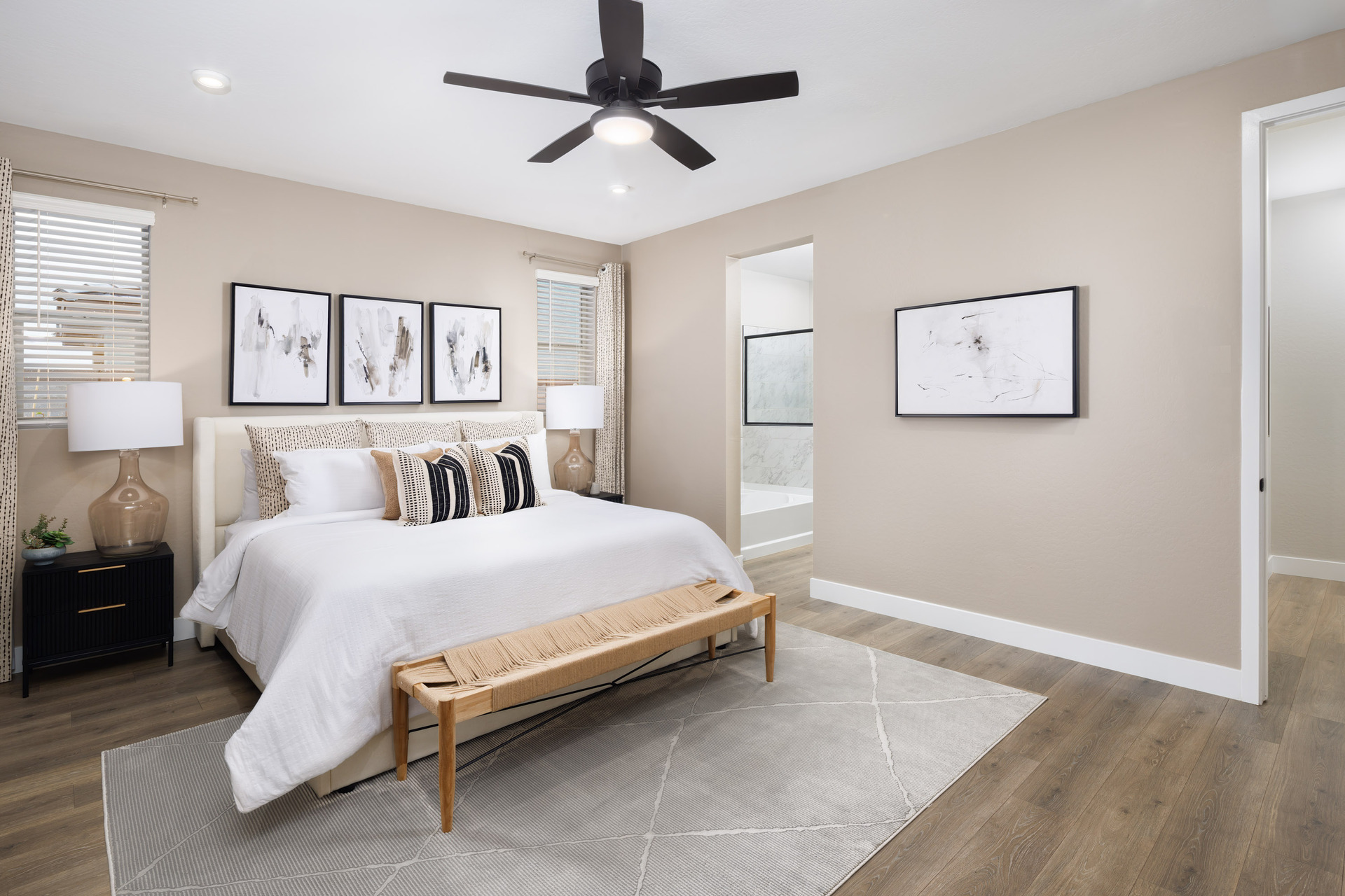 spacious bedroom with a large white bed and a wooden bench