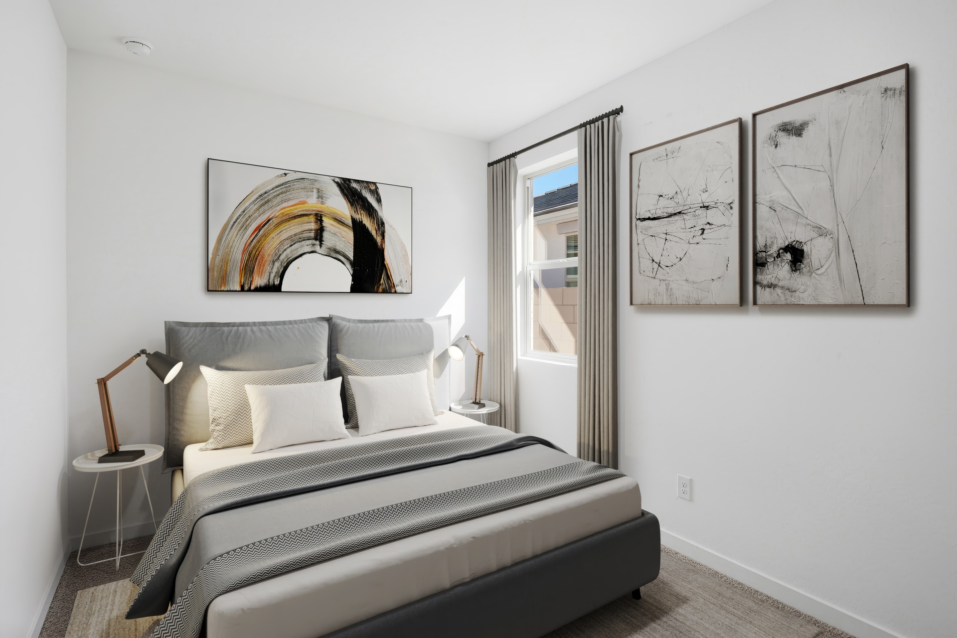bedroom with a large bed with a dark grey duvet cover, light brown rug, and a reading lamp