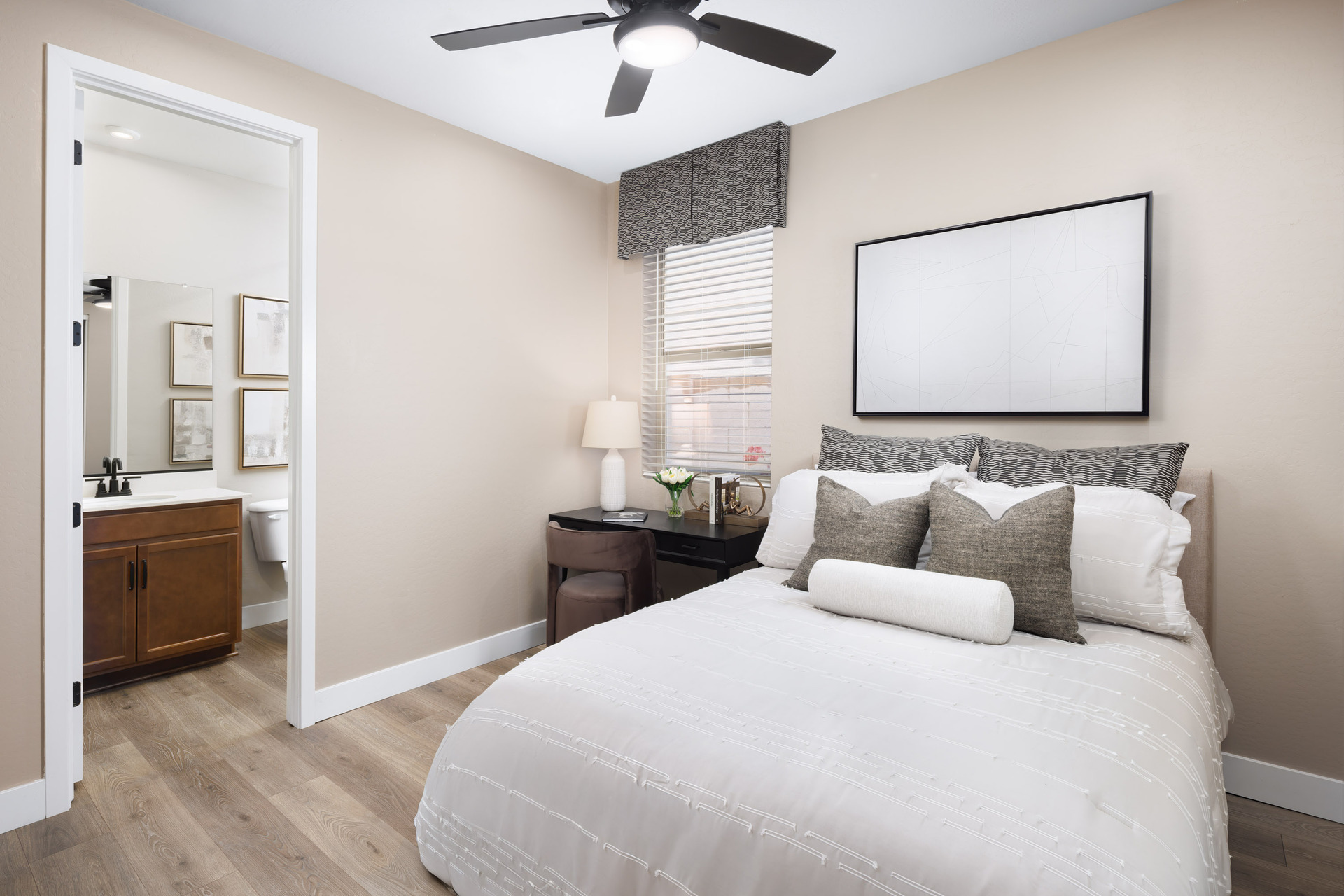 bedroom with a large white bed and a wooden vanity desk