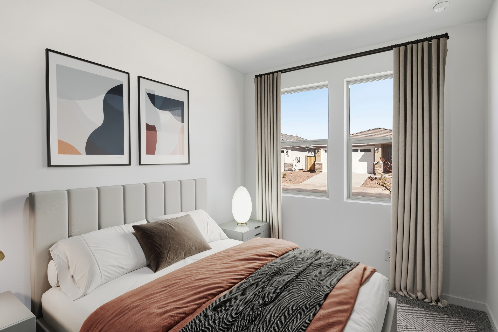 bedroom with a large bed, grey nightstands, and copper-colored duvet cover
