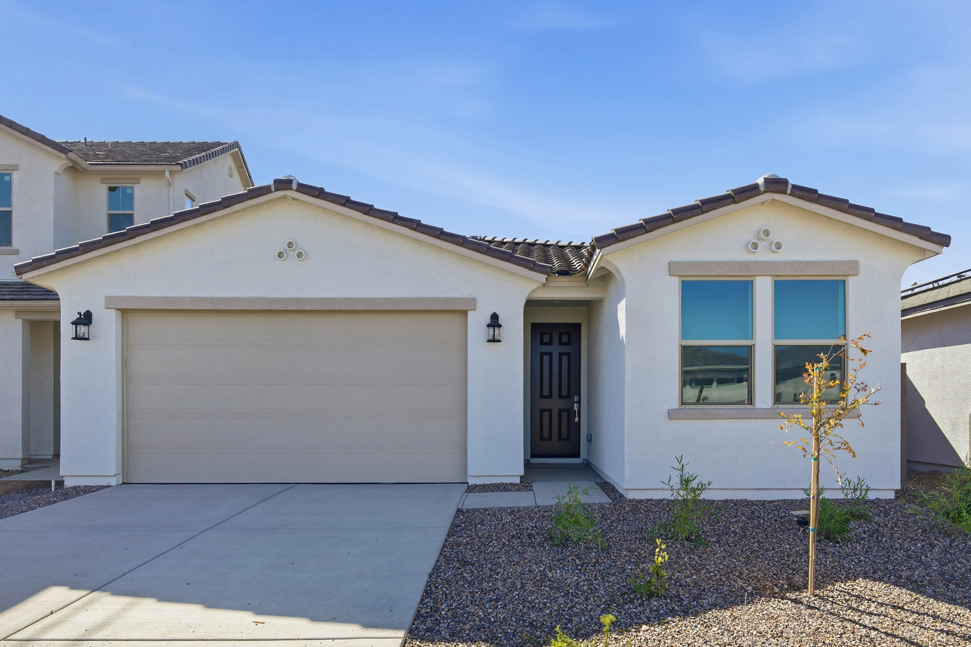 single-story single-family home with desert landscaping and concrete driveway