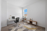 at home office with white desk, black office chair, and oak stand