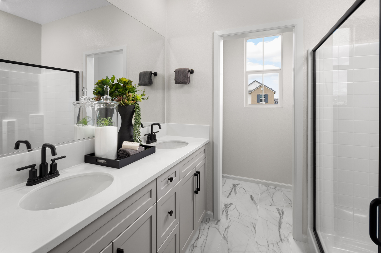 bathroom with tile flooring and gray cabinets
