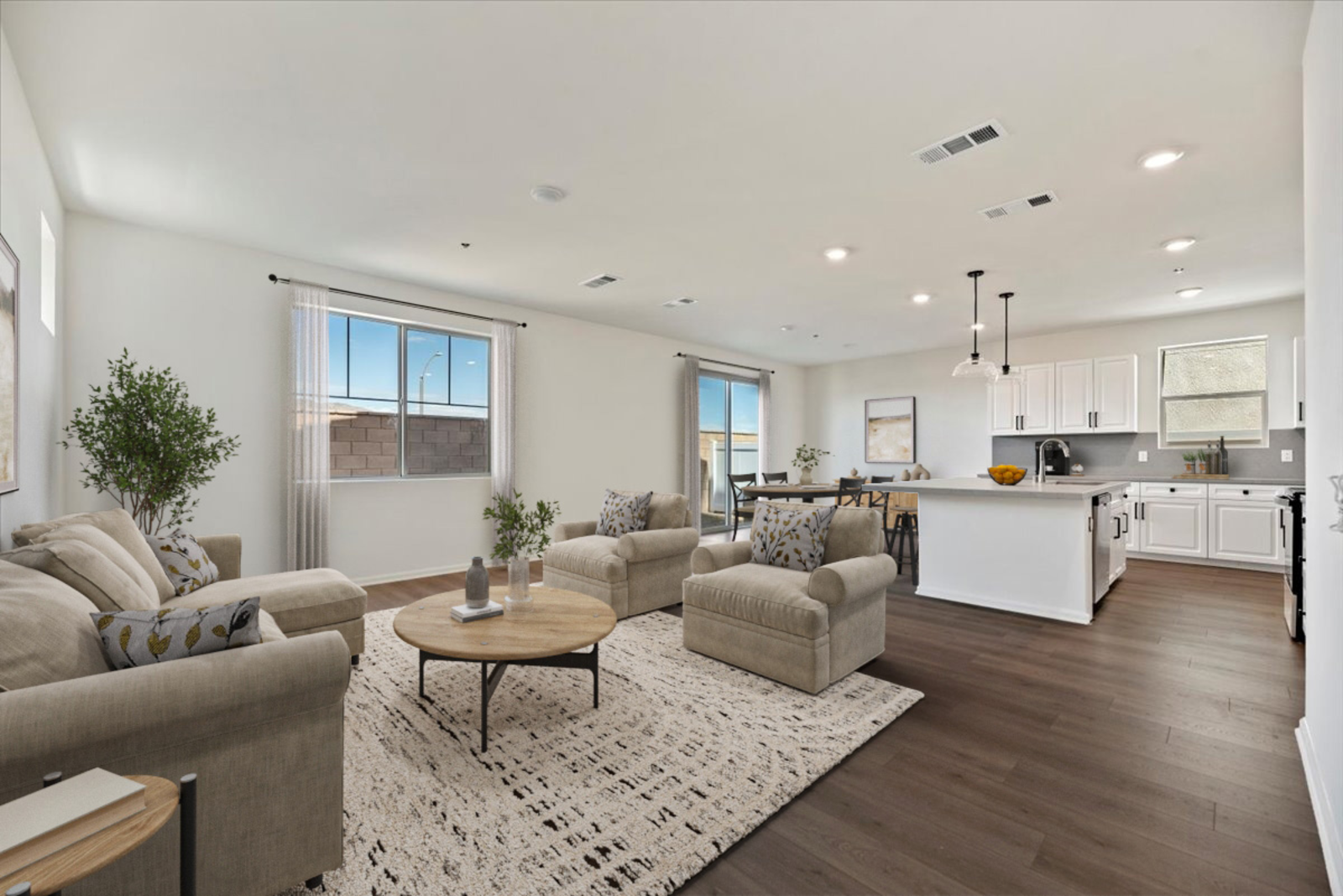 great room with a couch and coffee table leading to the dining room and kitchen